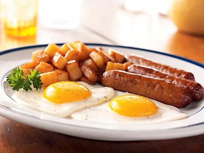 Desayuno equilibrado: huevos, papas doradas y salchichas a la parrilla con un mínimo de grasa
